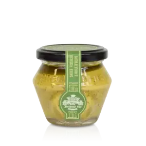 Glasskrukke med grønn etikett som inneholder pistasjpesto med olivenolje
